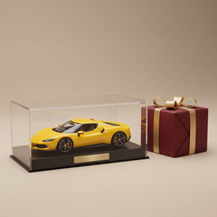 Model car in a display case with a red and gold gift box — gifts for car enthusiasts