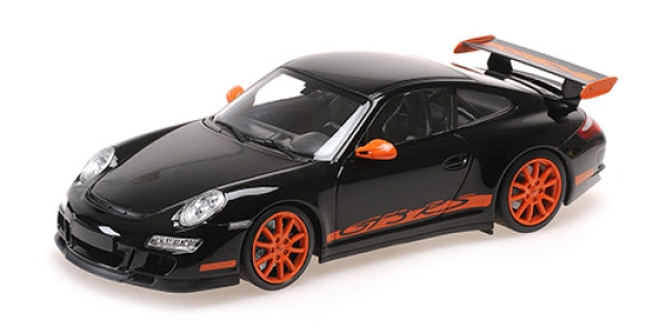 1:18 scale diecast model car, black with orange accents, large rear wing, Porsche design