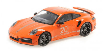 Orange 1:18 scale Porsche diecast model car with racing stripes and number 20 detailing