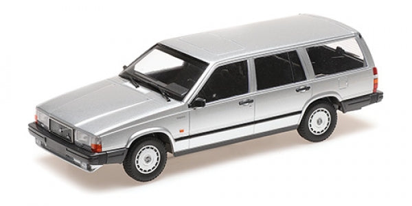Silver diecast model station wagon car in 1:18 scale, side angle view on white background