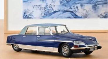 1:18 scale blue diecast model classic car with chrome accents on tabletop display