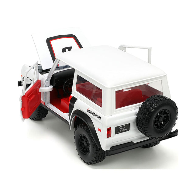 https://cdn.shopify.com/s/files/1/0504/9925/6496/files/1973-ford-bronco-008-white-with-red-and-black-stripes-and-red-interior-with-extra-wheels-just-trucks-series-124-diecast-model-car-by-jada-235817.jpg?v=1748419128