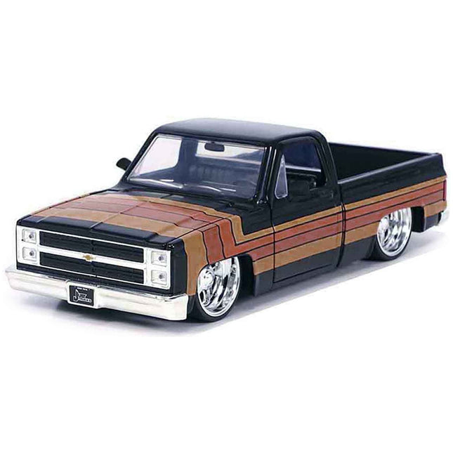 https://cdn.shopify.com/s/files/1/0504/9925/6496/files/1985-chevrolet-c-10-pickup-truck-black-with-stripes-and-paradox-wheels-just-trucks-series-124-diecast-model-car-by-jada-514745.jpg?v=1748404992
