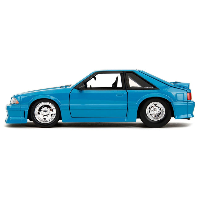 https://cdn.shopify.com/s/files/1/0504/9925/6496/files/1989-ford-mustang-gt-blue-with-black-hood-stripes-fast-furious-series-124-diecast-model-car-by-jada-386608.jpg?v=1748405518