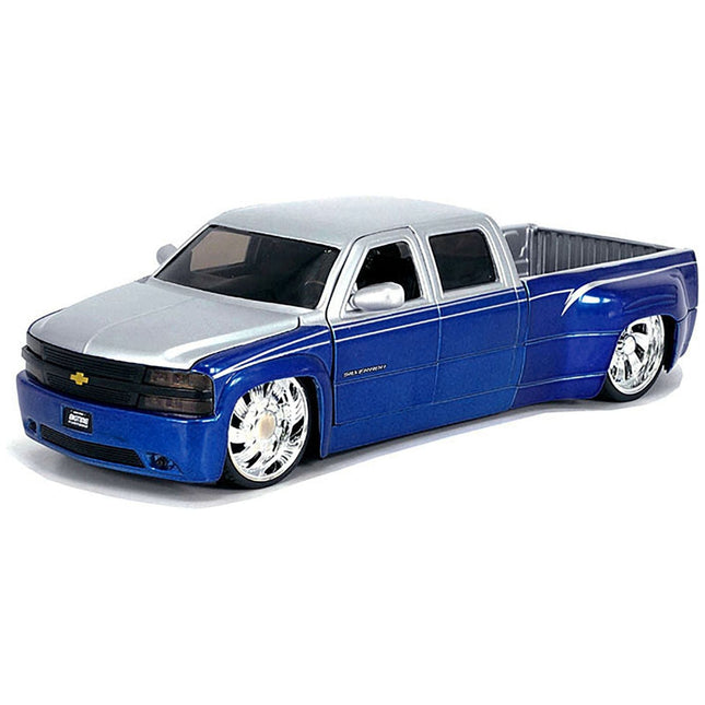 https://cdn.shopify.com/s/files/1/0504/9925/6496/files/1999-chevrolet-silverado-dually-pickup-truck-blue-metallic-and-silver-with-custom-kmc-wheels-just-trucks-series-124-diecast-model-car-by-jada-197833.jpg?v=1748405278