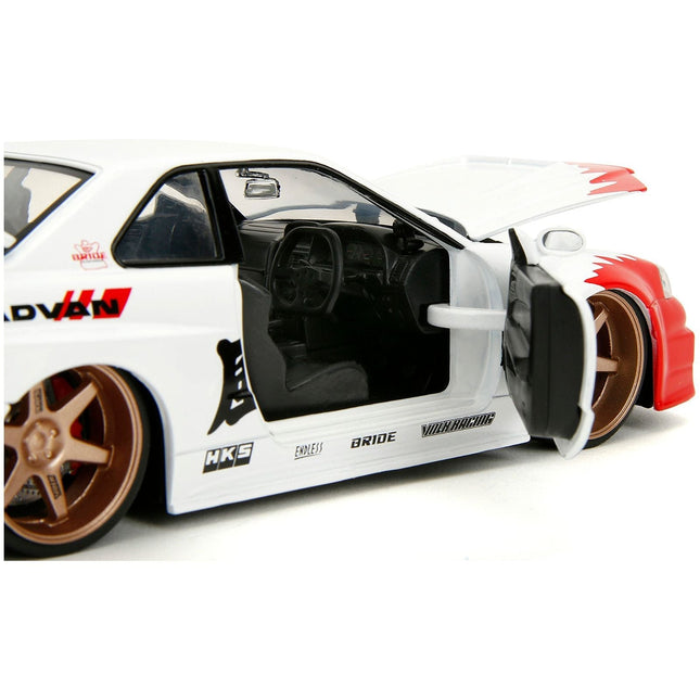 https://cdn.shopify.com/s/files/1/0504/9925/6496/files/2002-nissan-skyline-gt-r-r34-rhd-right-hand-drive-white-with-red-graphics-and-ryu-diecast-figure-street-fighter-video-game-anime-hollywood-rides-series-124-diec-465036.jpg?v=1748405276