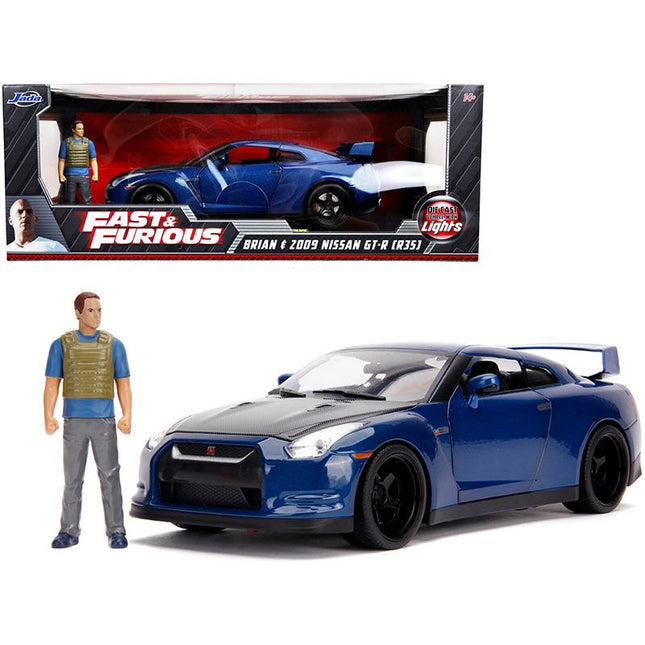 https://cdn.shopify.com/s/files/1/0504/9925/6496/files/2009-nissan-gt-r-r35-blue-metallic-and-carbon-with-lights-and-brian-figurine-fast-furious-movie-118-diecast-model-car-by-jada-291378.jpg?v=1748419233