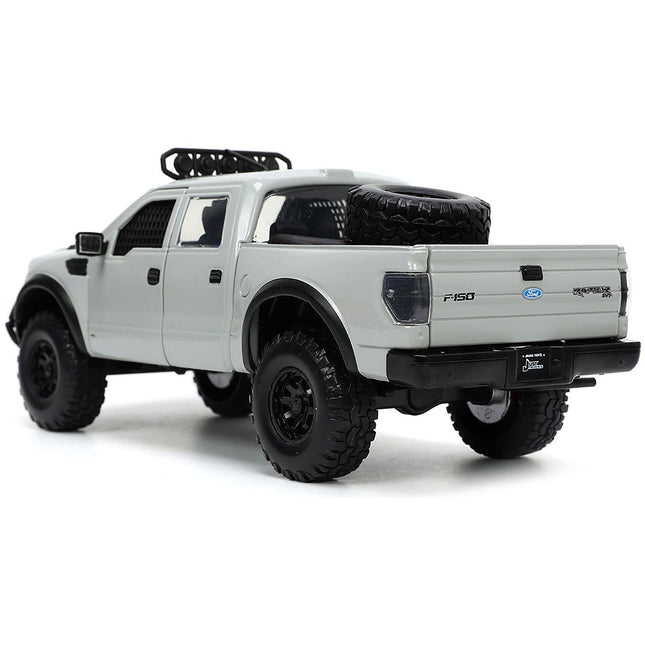 https://cdn.shopify.com/s/files/1/0504/9925/6496/files/2011-ford-f-150-svt-raptor-pickup-truck-light-gray-with-extra-wheels-just-trucks-series-124-diecast-model-car-by-jada-580869.jpg?v=1748403837