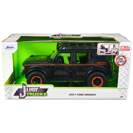 https://cdn.shopify.com/s/files/1/0504/9925/6496/files/2021-ford-bronco-matt-black-with-orange-stripes-and-roof-rack-addictive-desert-designs-just-trucks-series-124-diecast-model-car-by-jada-921157.jpg?v=1748405396