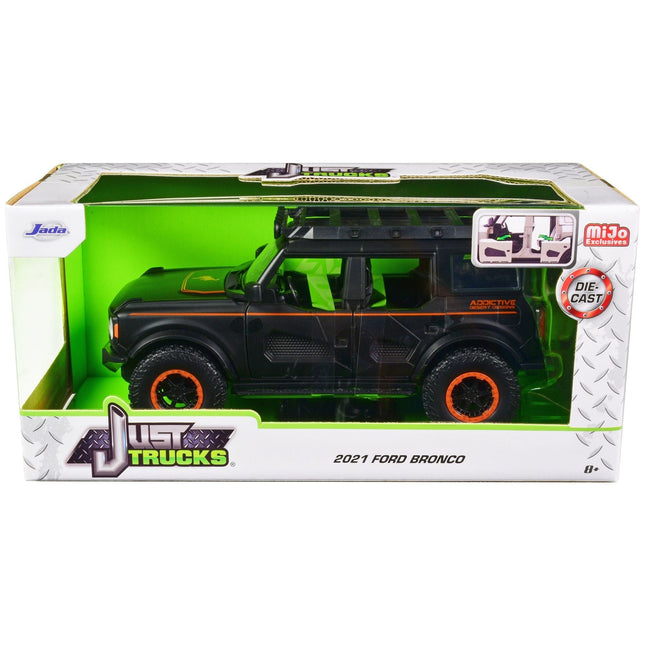 https://cdn.shopify.com/s/files/1/0504/9925/6496/files/2021-ford-bronco-matt-black-with-orange-stripes-and-roof-rack-addictive-desert-designs-just-trucks-series-124-diecast-model-car-by-jada-921157.jpg?v=1748405396