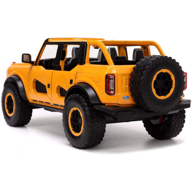 https://cdn.shopify.com/s/files/1/0504/9925/6496/files/2021-ford-bronco-orange-metallic-with-extra-wheels-just-trucks-series-124-diecast-model-car-by-jada-472416.jpg?v=1748419221