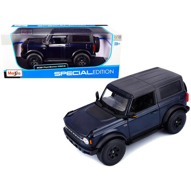 https://cdn.shopify.com/s/files/1/0504/9925/6496/files/2021-ford-bronco-wildtrak-dark-blue-metallic-with-dark-gray-top-special-edition-118-diecast-model-car-by-maisto-229368.jpg?v=1748418491