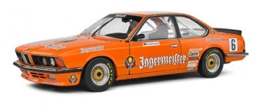 Orange BMW 635 CSi race car diecast model with detailed racing decals, side view