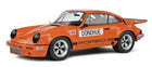 Orange Porsche diecast model car, classic racing design with Donohue decals, 1:18 scale.
