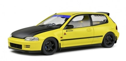 Yellow 1:18 scale diecast model car with black hood, sporty wheels, and racing decals