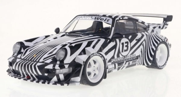 1:18 scale diecast Porsche model car with black and white racing livery and large rear wing