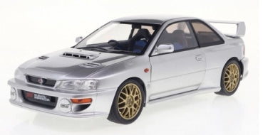 Silver 1:18 scale diecast model car with gold wheels and rear spoiler, rally-inspired design