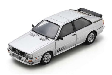White diecast Audi rally car model with detailed wheels and black rear spoiler, 1:18 scale.