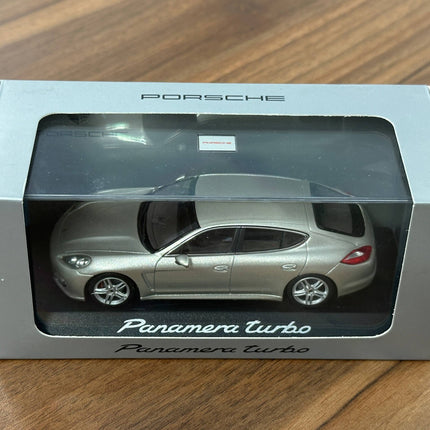 Minichamps Porsche Panamera Turbo – Gold – 1:43 Diecast Model - studio product photo of the scale model