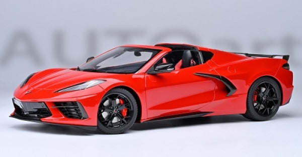 Red diecast model sports car in 1:18 scale with black wheels on a white background
