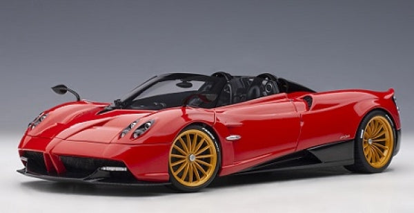 Red diecast model sports car with gold wheels, detailed exterior, studio background