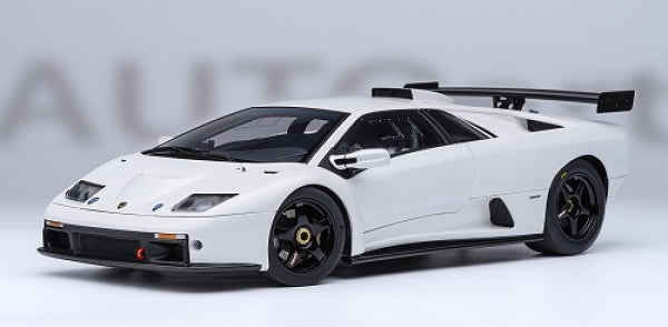 White diecast Lamborghini model car with rear wing, black wheels, 1:18 scale, studio background