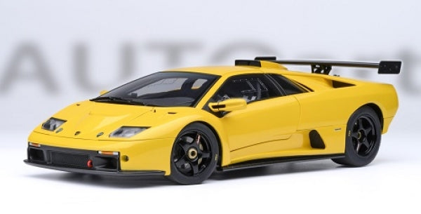 Yellow 1:18 scale diecast model car with black rear wing and sporty design on white background