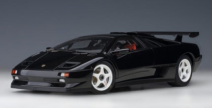 Black diecast model supercar with white wheels and rear spoiler on a gray background