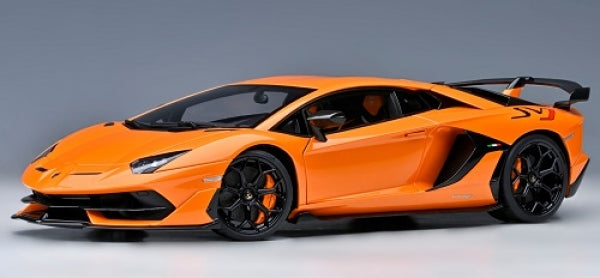 Orange diecast model car in 1:18 scale with black wheels and aerodynamic spoiler