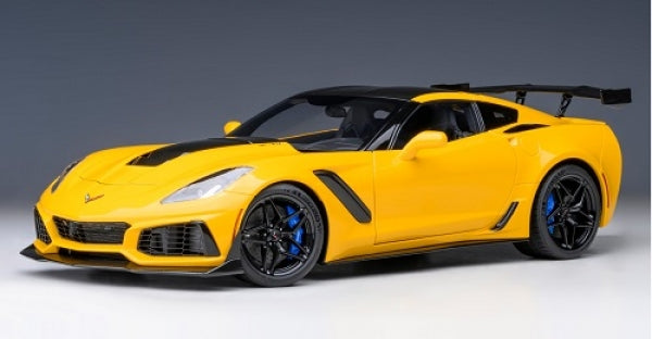 Yellow diecast Corvette model car with black details and rear wing, 1:18 scale