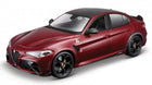 Red diecast model sports car, four-door sedan with black wheels and green badge