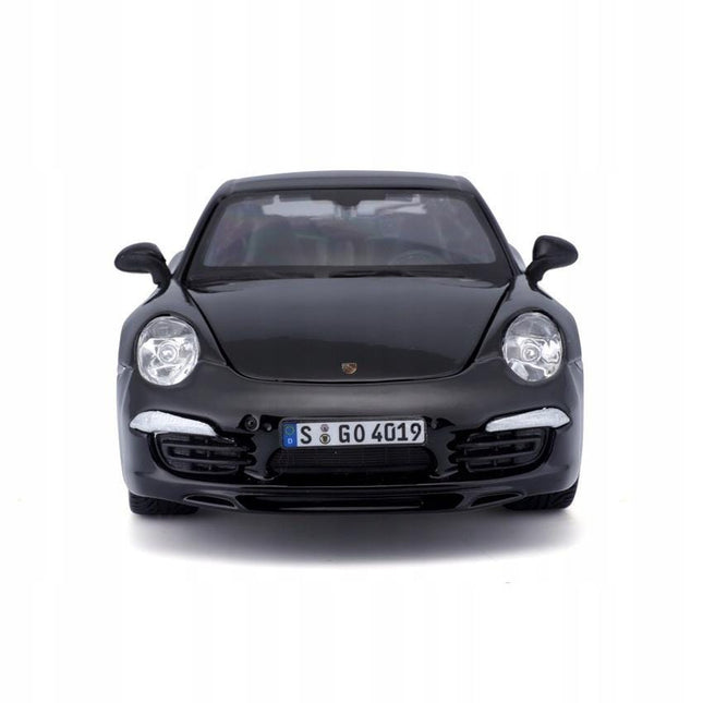 Head-on front view of a 1:24 scale black Porsche 911 Carrera S 2024 diecast model. The sports car faces forward showing its iconic round headlights, sleek nose, wide front bumper and low stance. Includes a front license plate and air intakes, with silver trim details against the glossy black body.