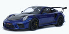 1:18 scale blue diecast model sports car with black hood, rear spoiler, and detailed rims