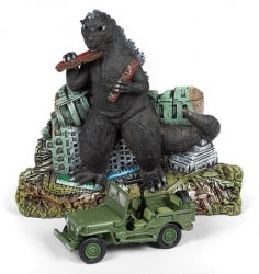 Diecast green military jeep model with Godzilla figurine and ruined city backdrop.