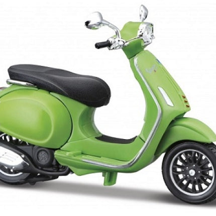 Green diecast model Vespa scooter with black seat on white background