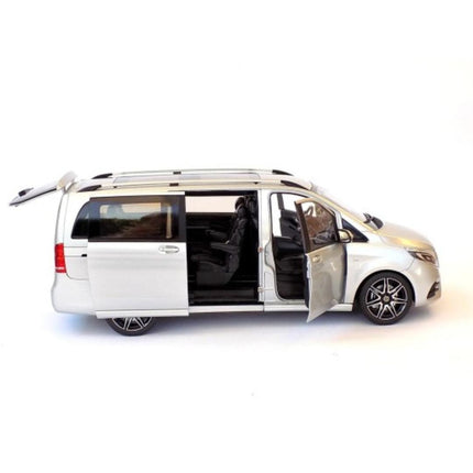 Driver side profile of a 1:18 scale Mercedes-Benz V-Class (W447) AMG Line 2018 diecast model in brilliant silver metallic, with the driver's front door, sliding side door, and tailgate open to reveal the beige interior and spacious cargo area. The long van body features black roof rails and multi-spoke wheels.