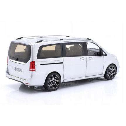 Rear-left three-quarter view of a 1:18 scale Mercedes-Benz V-Class (W447) AMG Line 2018 diecast model in brilliant silver metallic, showing the tailgate closed and driver’s side sliding door closed, highlighting the long van silhouette, black roof rails, tinted windows, and multi-spoke wheels.