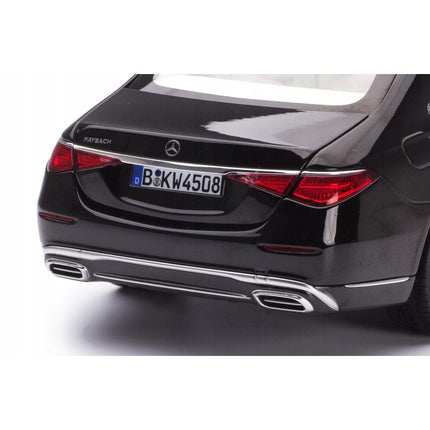 Close‑up view of the rear of a 1:18 scale Mercedes‑Maybach S 680 4Matic (X223) diecast model finished in glossy black, focusing on the sleek LED tail lights, chrome bumper trim with integrated exhaust outlets, Maybach script badge and detailed license plate 'B KW 4503'.