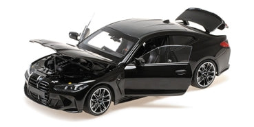 Black 1:18 scale diecast BMW model car with open doors, hood, and trunk on white background.