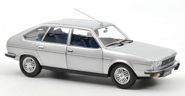 Silver diecast model car in 1:18 scale with detailed interior and realistic wheels