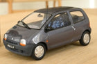 1:18 scale diecast model grey compact car with detailed interior on a wooden surface