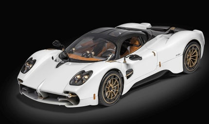 White diecast model car with bronze wheels and detailed interior on black background