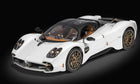 White diecast model car with bronze wheels and detailed interior on black background
