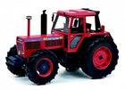 Red diecast model tractor with large black tires and detailed exterior design