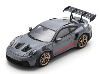 1:43 scale grey Porsche model car with rear wing, red accents, and gold wheels