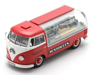 Red and white diecast model VW van with clear roof displaying miniature railway scene inside