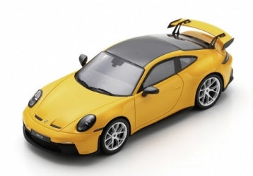 Yellow diecast model Porsche sports car with rear spoiler on white background