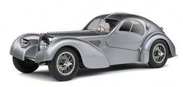 Silver vintage diecast model car 1:18 scale with classic curved design, displayed on white.