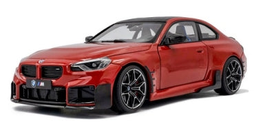 Red diecast BMW M sports car model with black accents in 1:18 scale, front angle view.