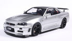 Silver diecast model car Nissan Skyline GT-R R34 in 1:18 scale with black wheels and rear spoiler